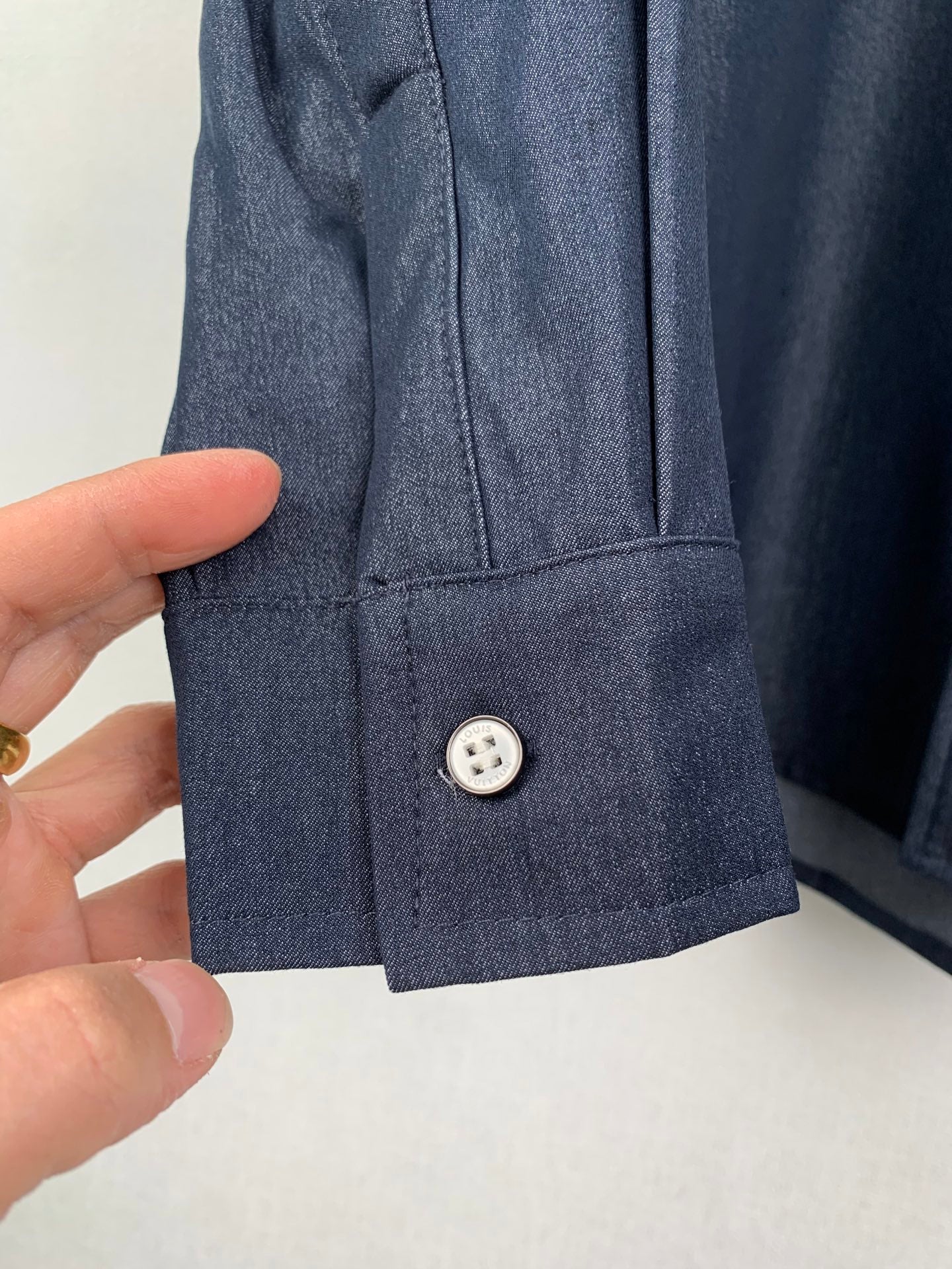 Dark blue shirt cuff close-up with single button detail