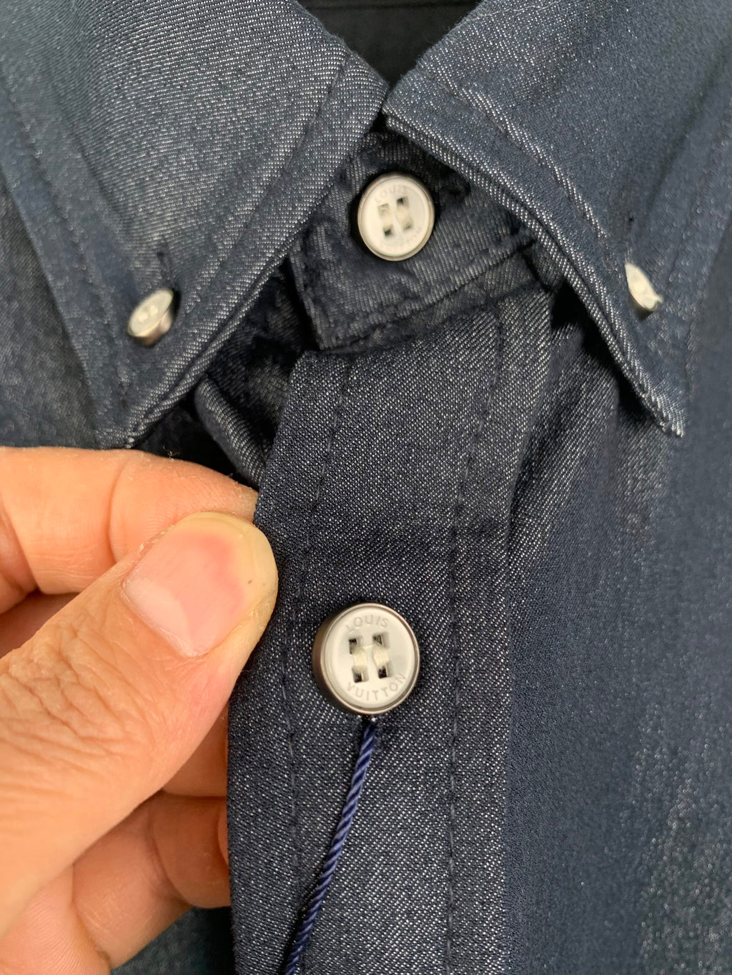 Dark blue shirt close-up of collar and front buttons with placket stitching