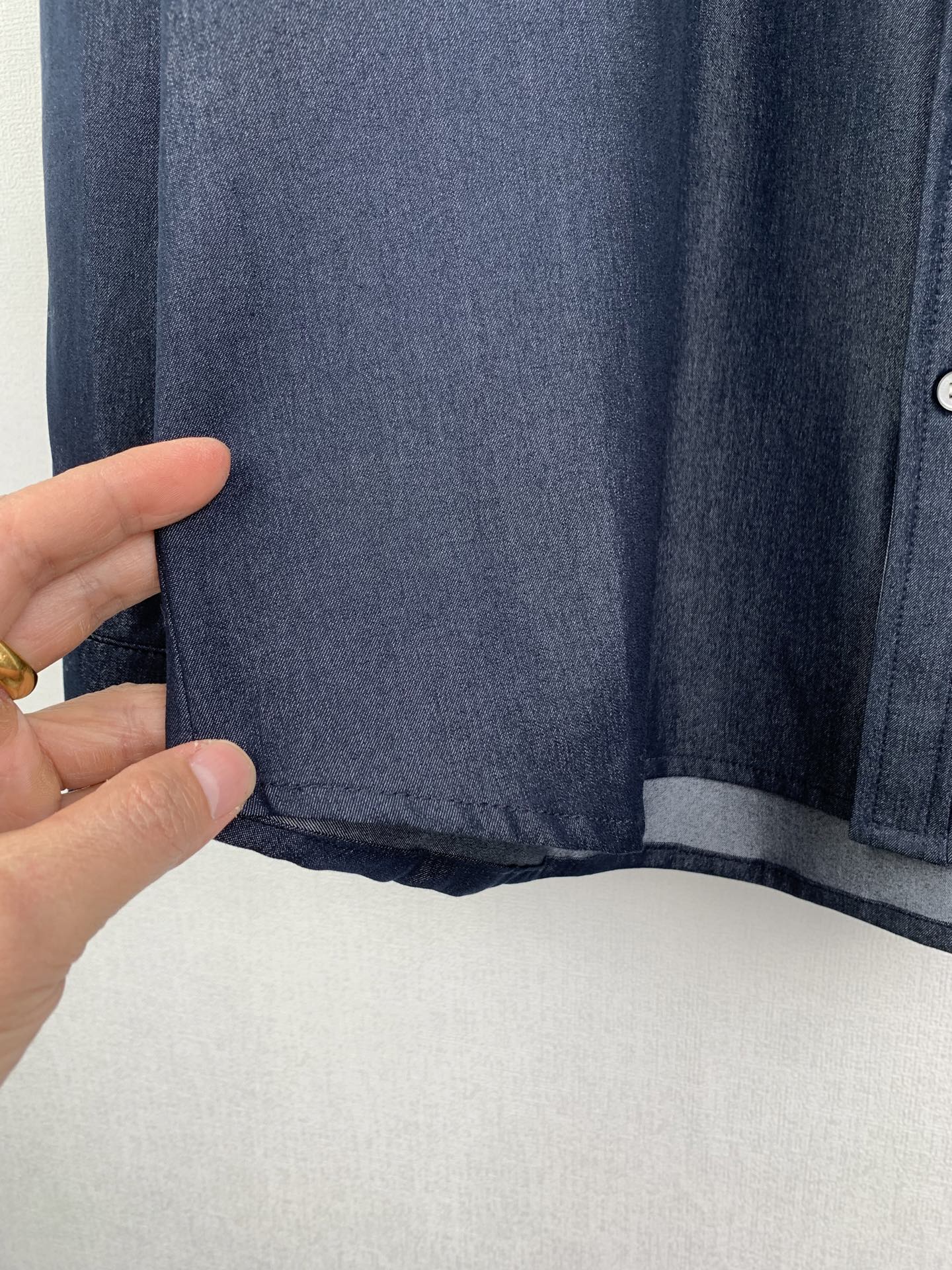 Dark blue shirt hem and inner underlayer in shadowed light