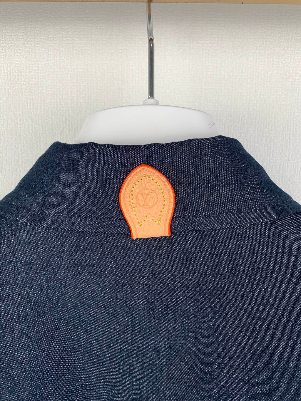 Dark blue shirt back with orange patch detail at upper yoke