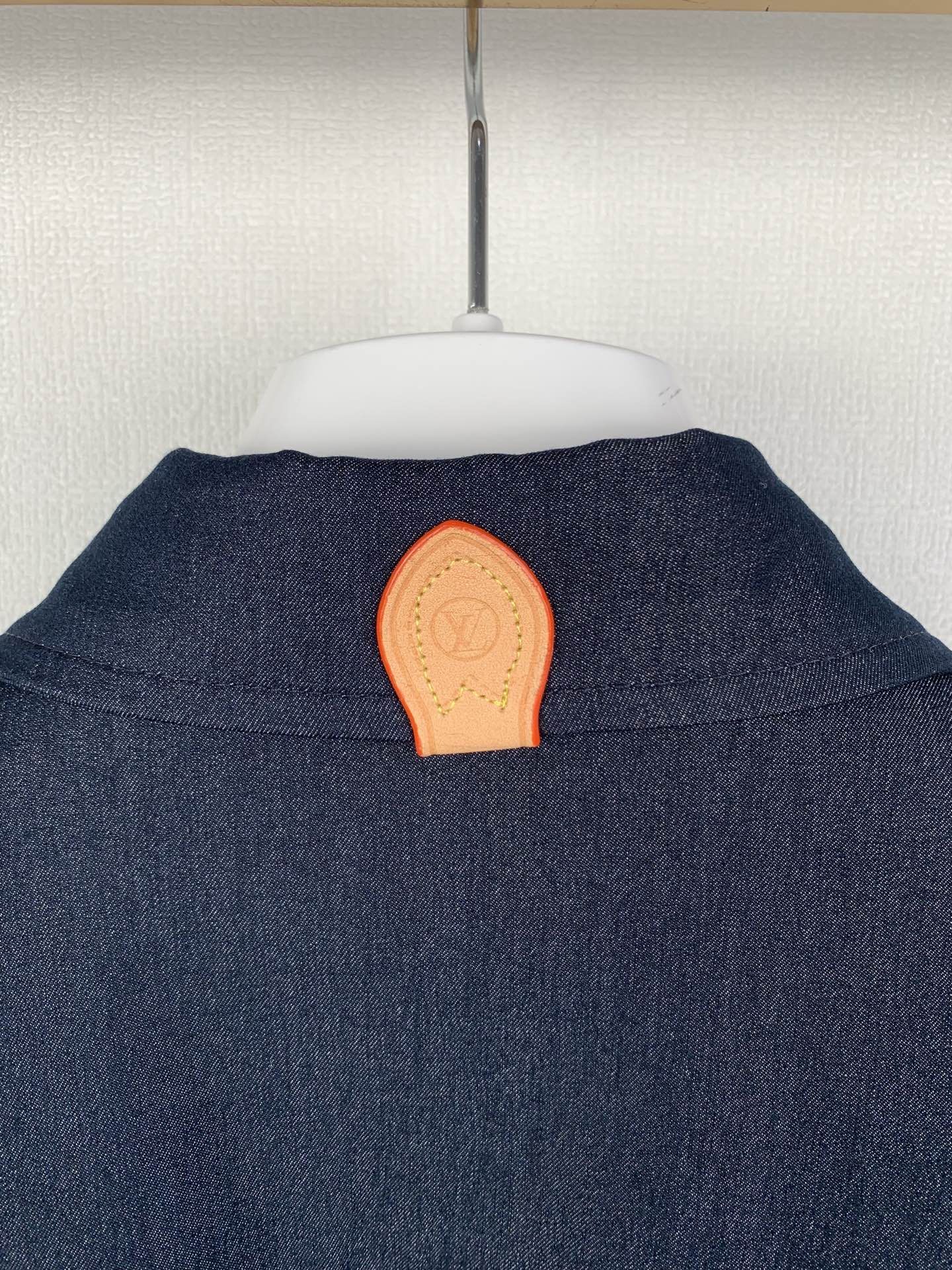 Dark blue shirt back with orange patch detail at upper yoke