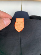 Louis Vuitton hood tag, orange leather with LV emblem on dark gray jacket hood