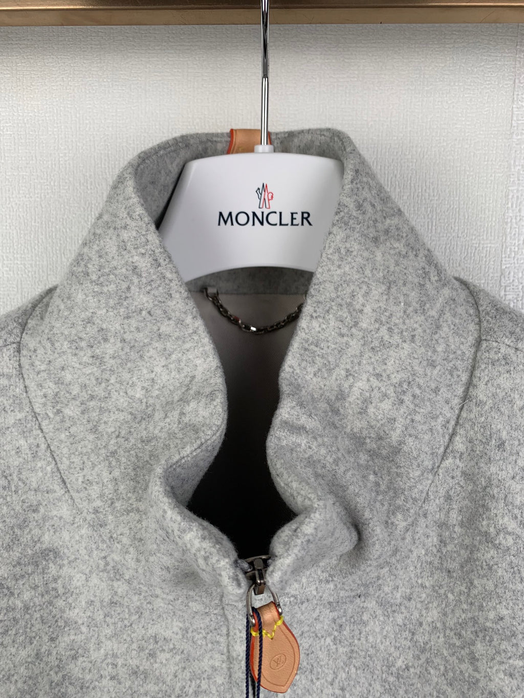 Grey zip-up jacket with stand collar and front zipper, fabric close-up
