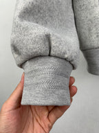 Grey zip-up jacket sleeve cuff and ribbed hem, close-up