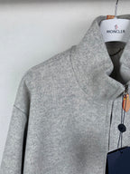 Grey zip-up jacket shoulder and front panel detail with zipper