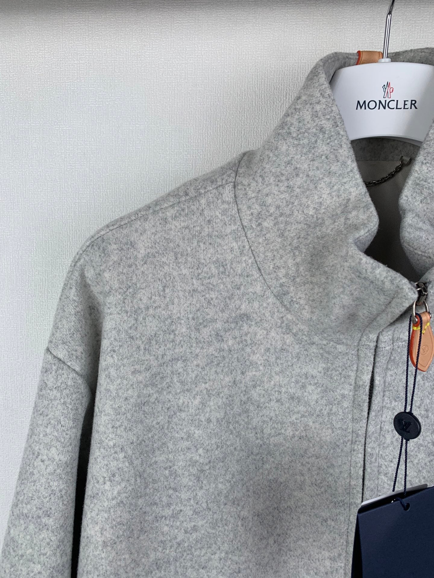 Grey zip-up jacket shoulder and front panel detail with zipper