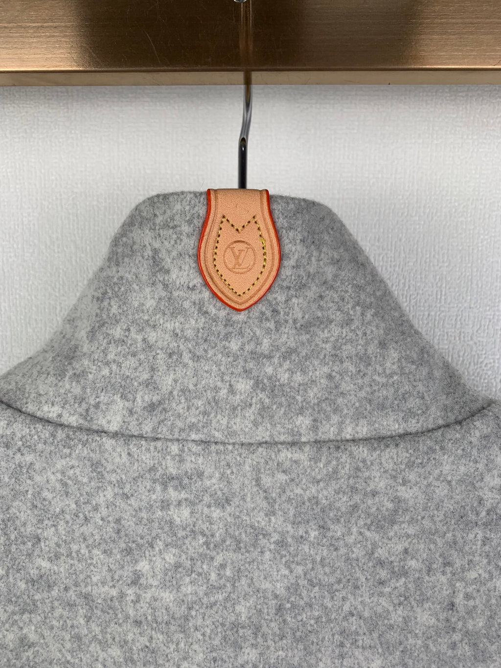 Grey zip-up jacket collar detail with tan leather patch
