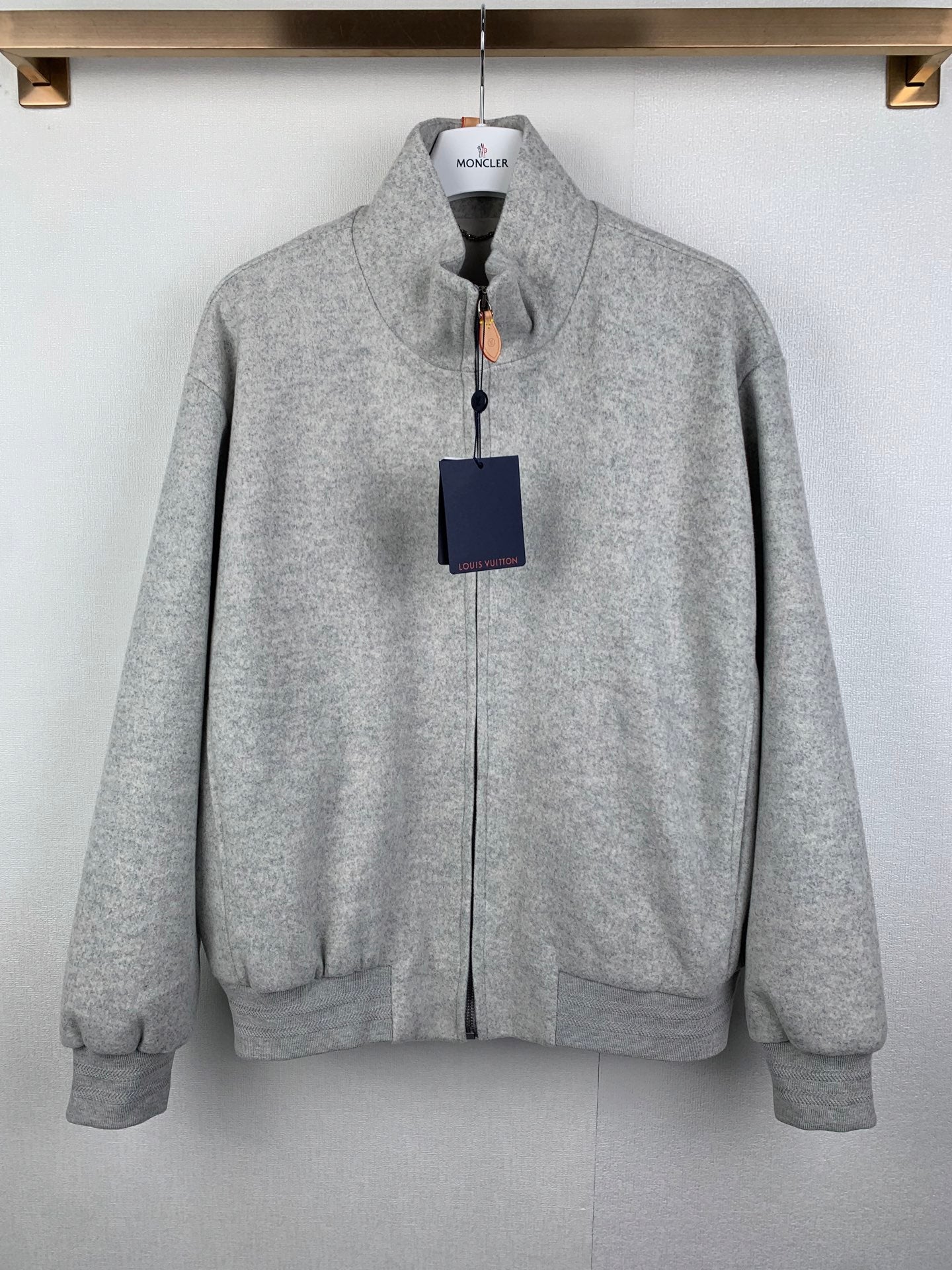 Grey zip-up jacket with stand collar, front zipper, and side pockets