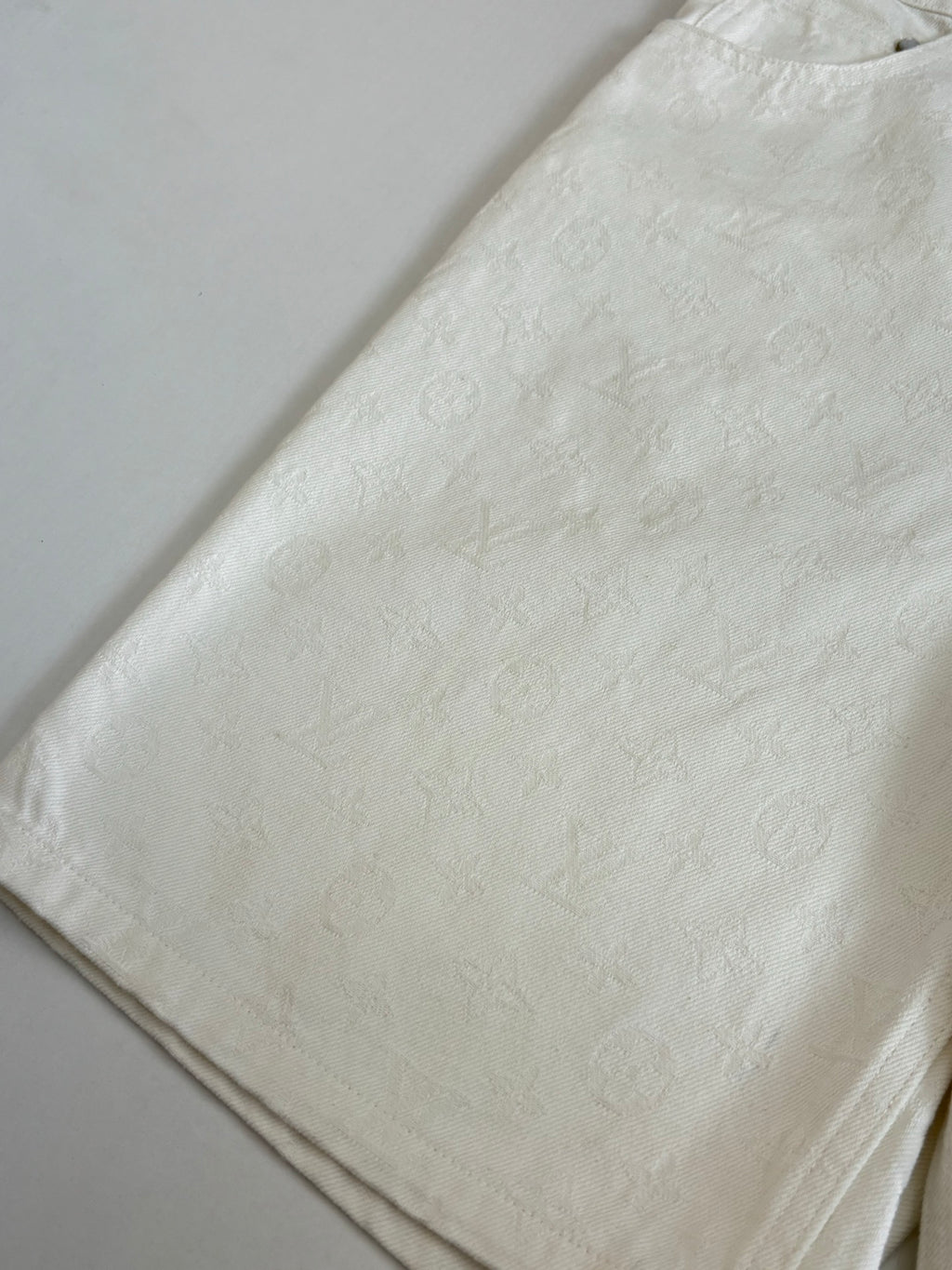White denim shorts folded, textured fabric close-up and side edge