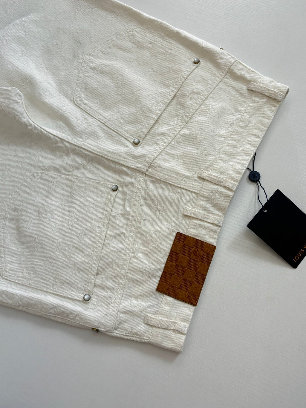 White denim shorts front detail, snap buttons and patch pocket