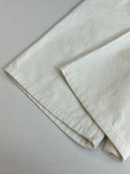 White denim shorts folded flat, visible hem and side seam