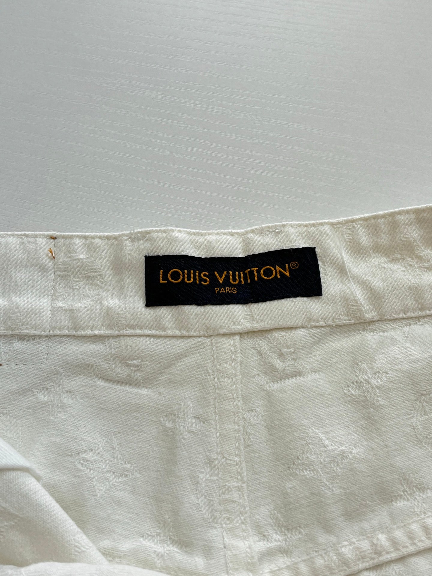 Beige pants waistband with black Louis Vuitton Paris label