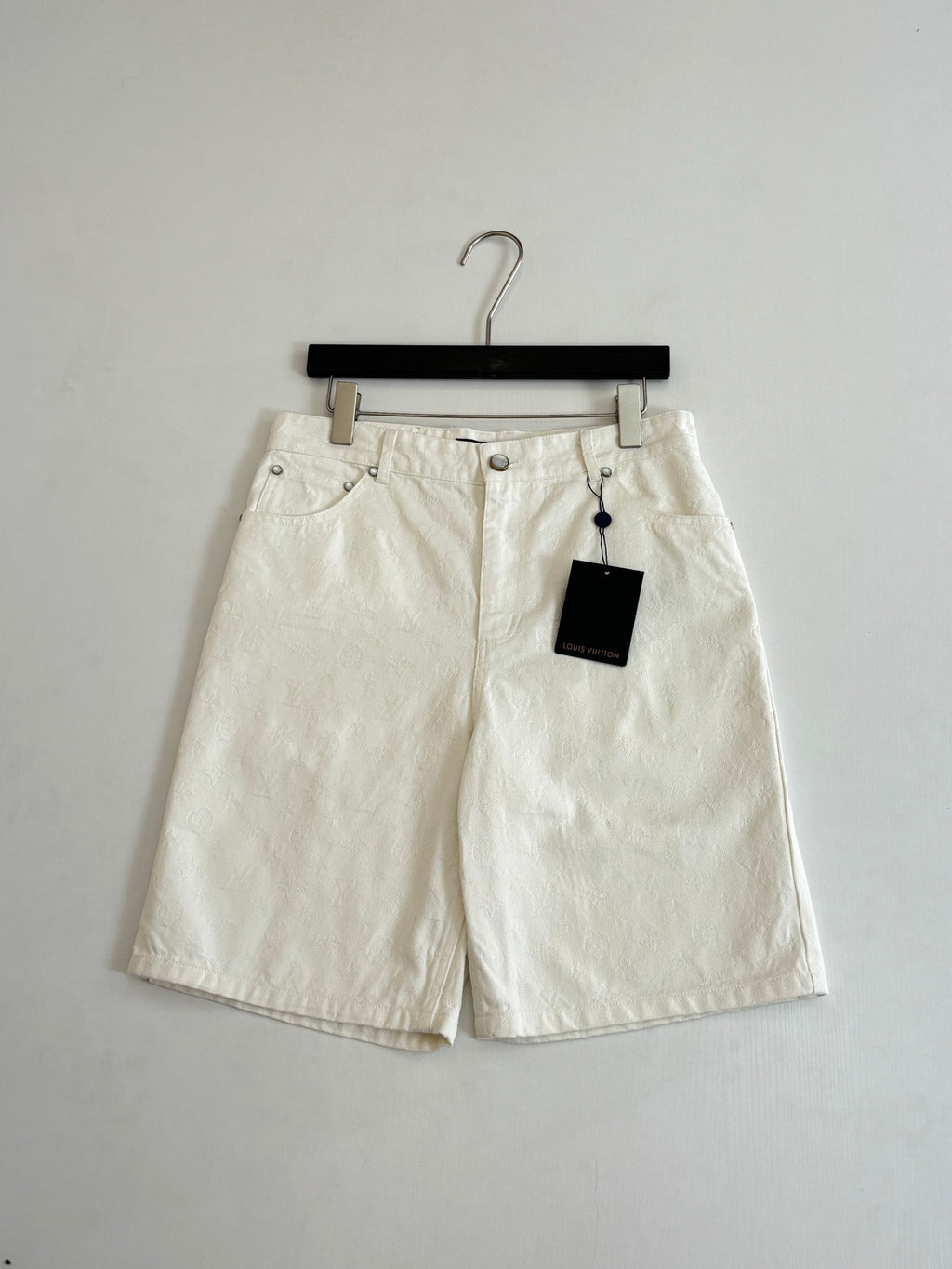 White denim shorts on hanger, button fly and two front pockets
