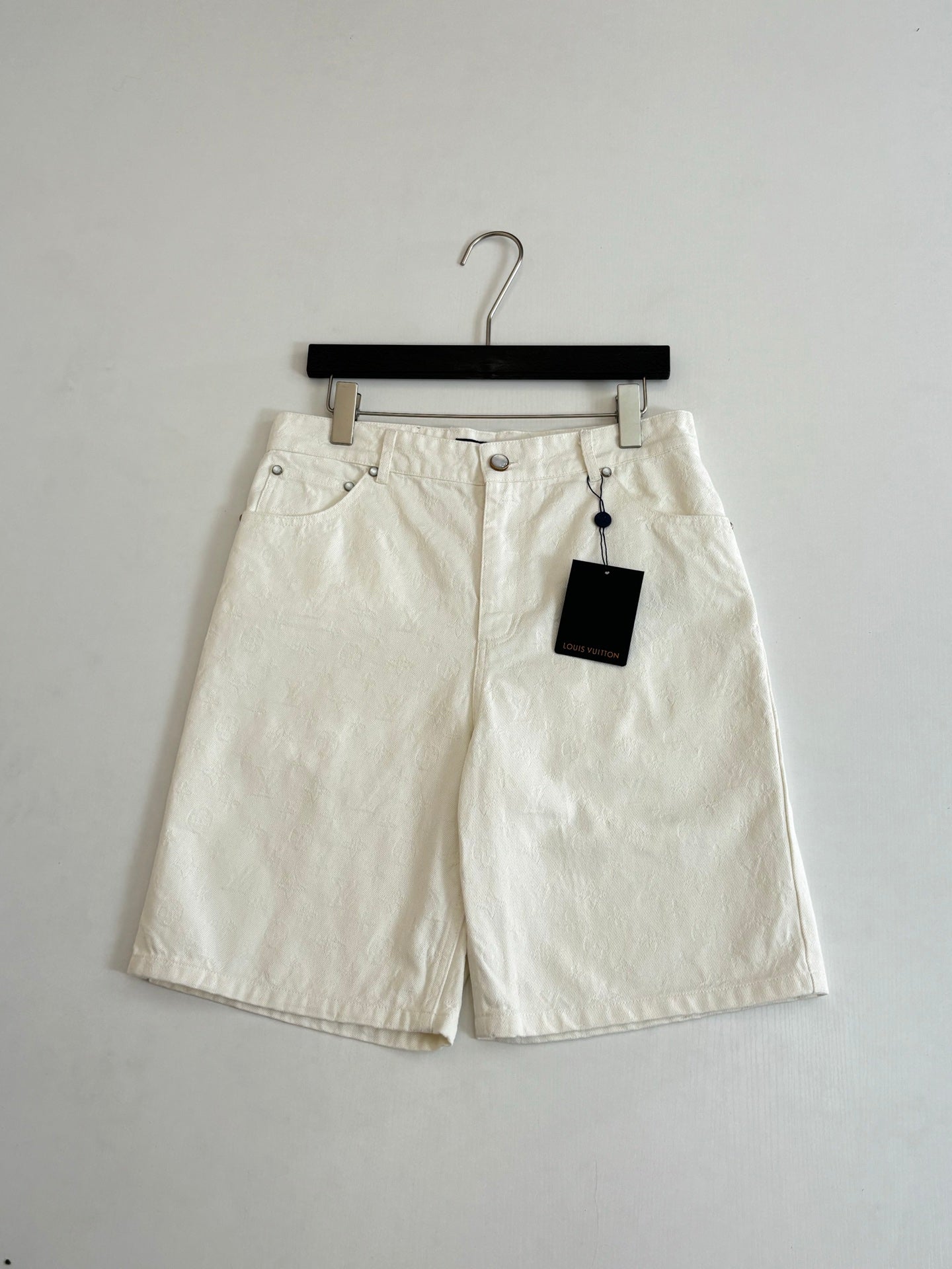 White denim shorts on hanger, button fly and two front pockets