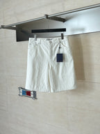 White denim shorts on hanger, elastic waistband and front button closure