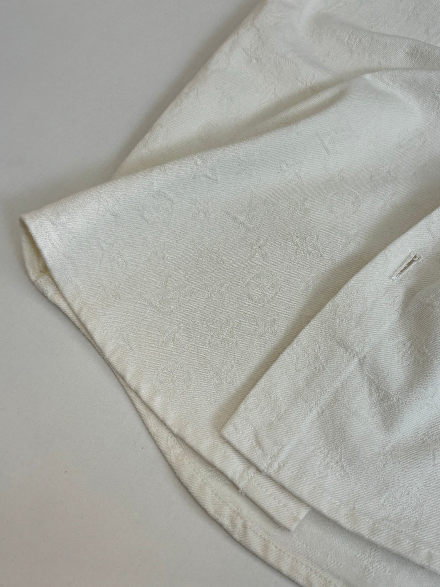Louis Vuitton white short-sleeve shirt fabric close-up with subtle texture