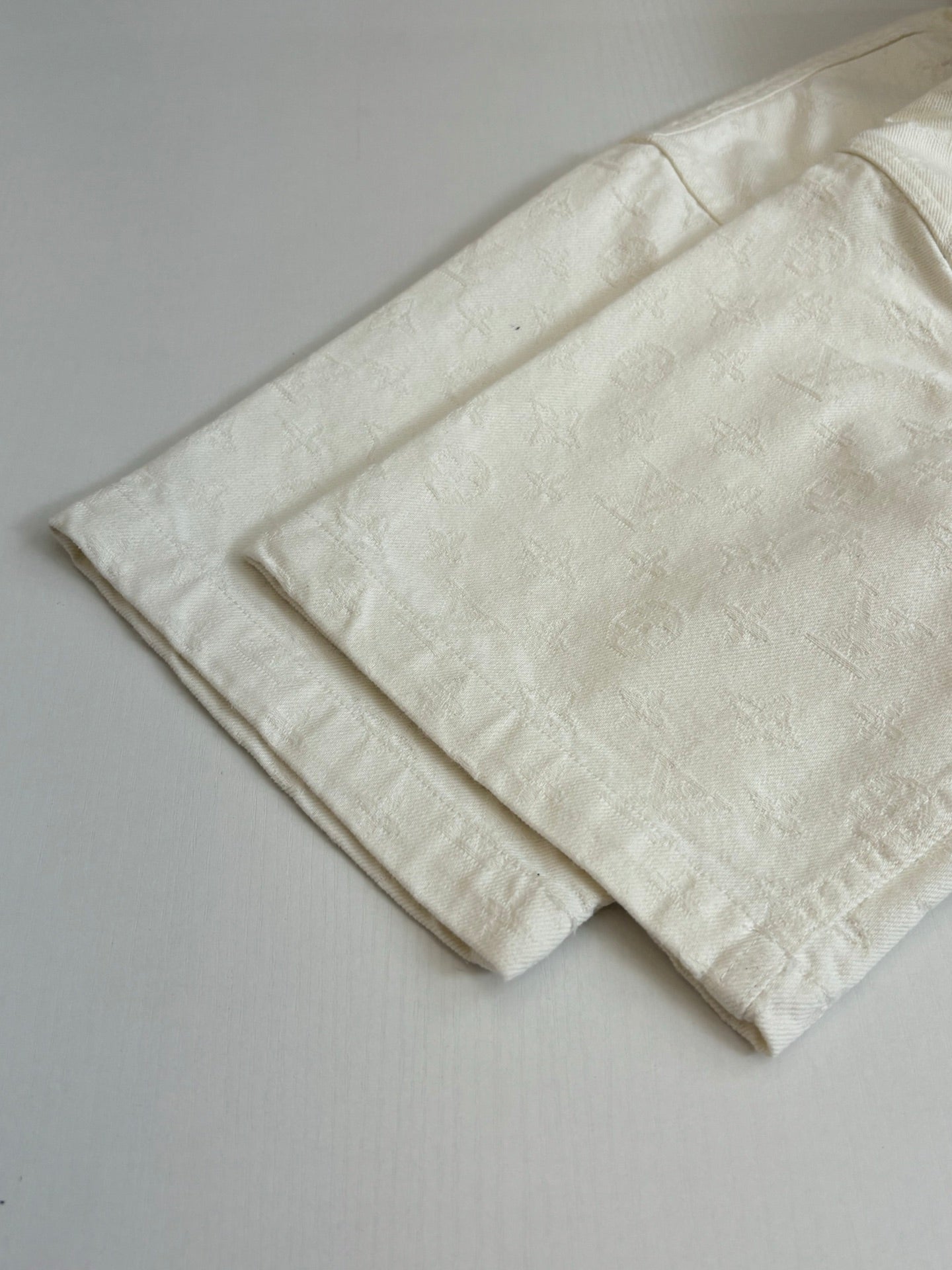 Louis Vuitton white short-sleeve shirt hem and fold detail, textured fabric