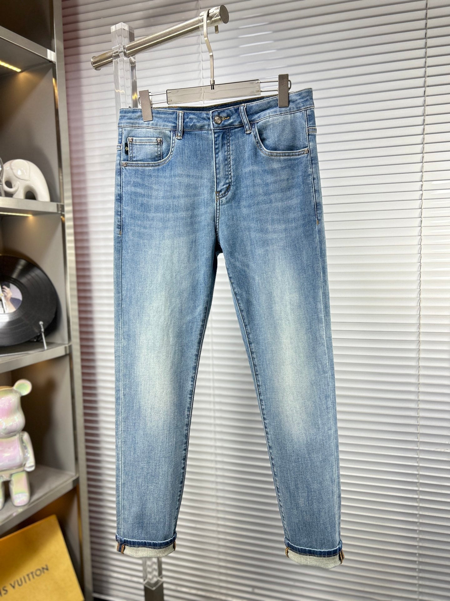 Light-blue denim jeans on hanger with straight leg and belt loops