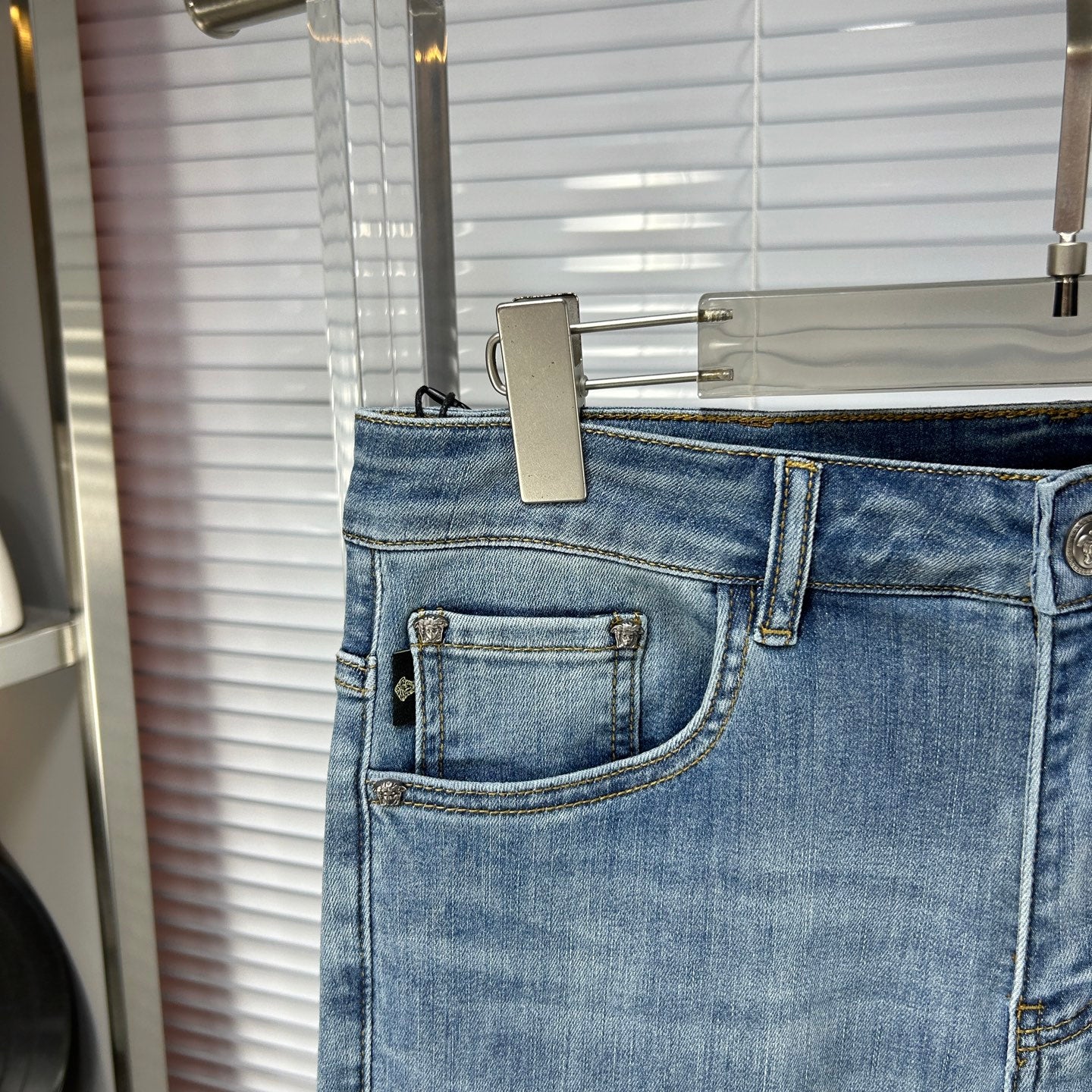 Front view of light-blue denim jeans with coin pocket and stitched belt loops