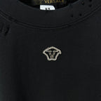 Black crew-neck T-shirt with small gold V emblem on the chest