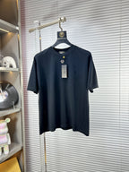Black crew-neck T-shirt with short sleeves and small gold V logo on chest