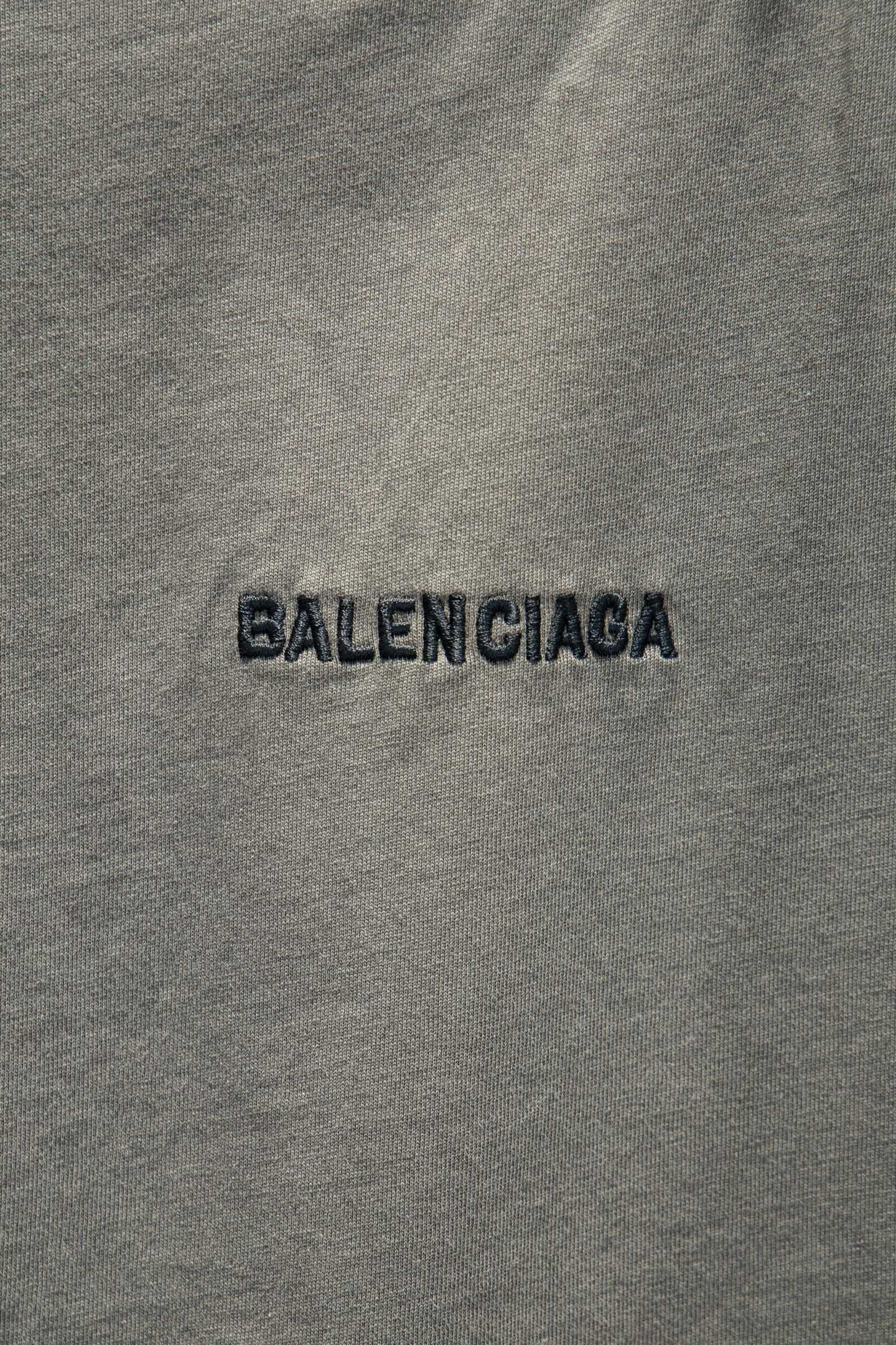 Balenciaga light gray T-shirt fabric close-up with BALENCIAGA logo text