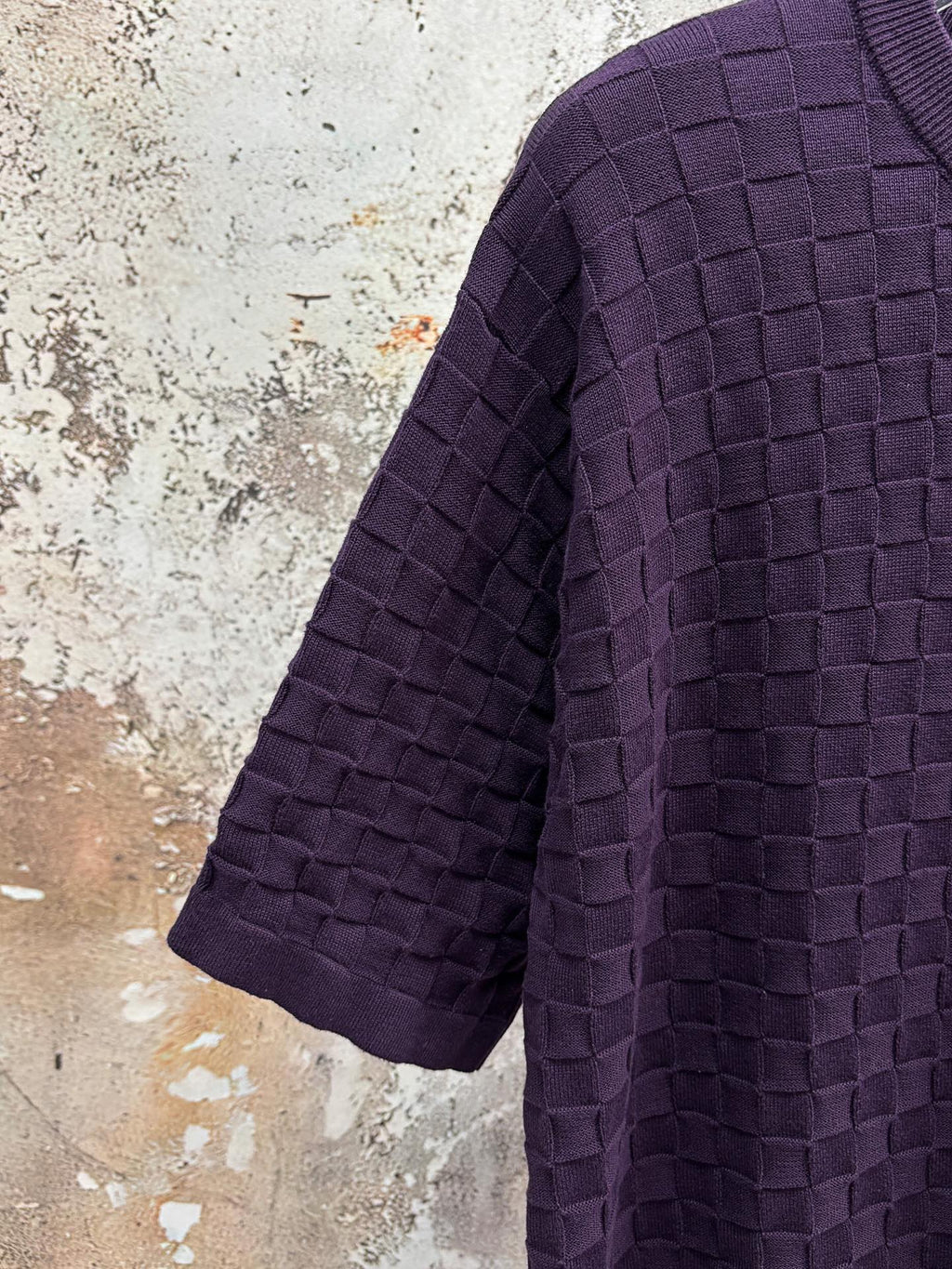 Purple textured knit T-shirt angled view of sleeve and side drape