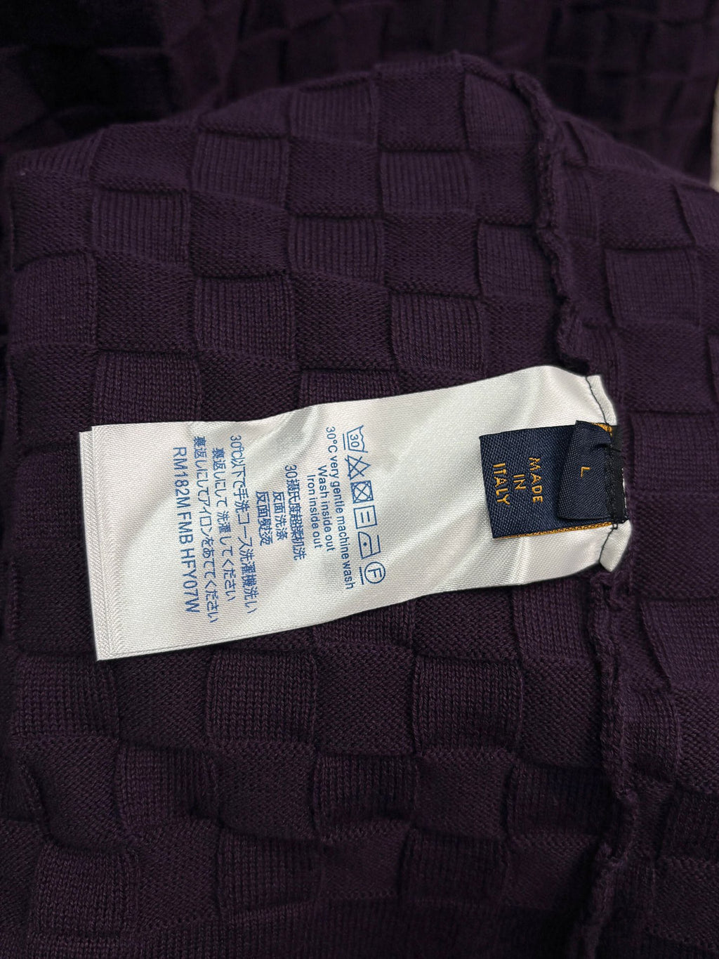 Purple textured knit T-shirt care label on interior neck seam