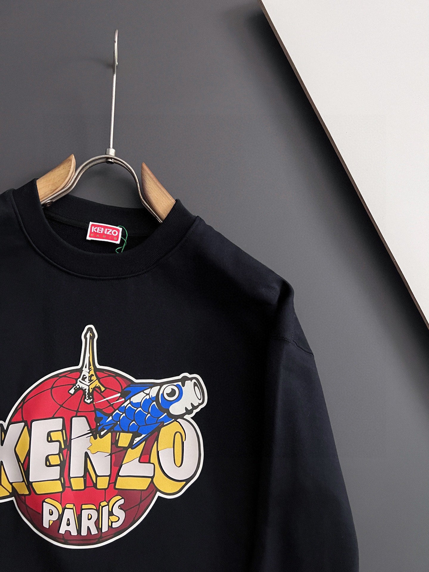Black sweatshirt with large "KENZO" and "PARIS" graphic across the front