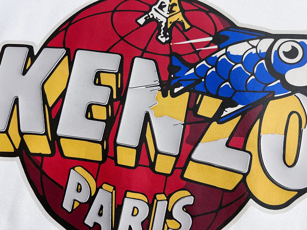 Close-up of Kenzo Paris graphic on white sweatshirt, red blue and yellow print