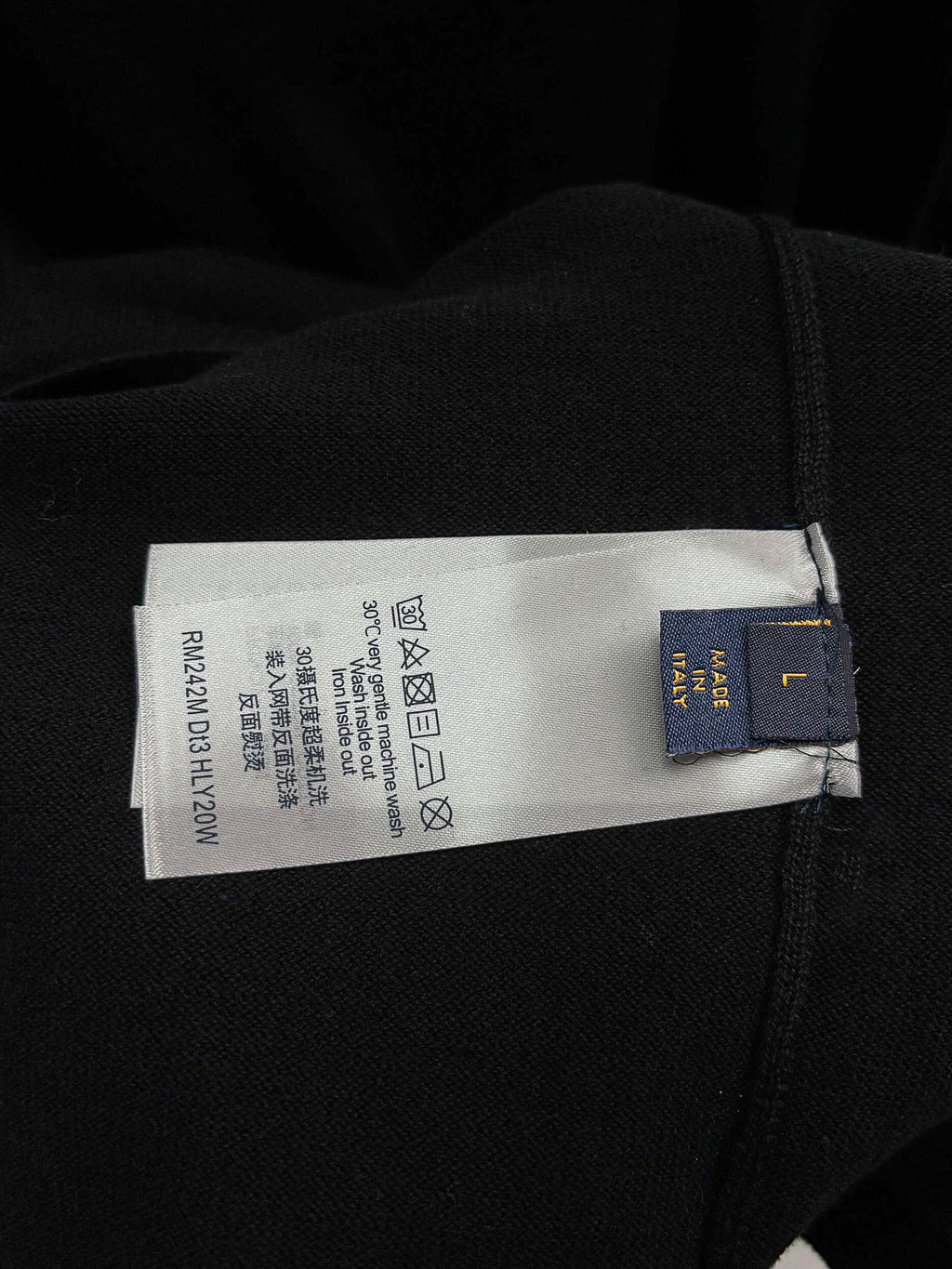 Black T-shirt care label with recycling symbols and size info