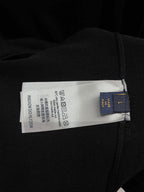 Black T-shirt care label with recycling symbols and size info