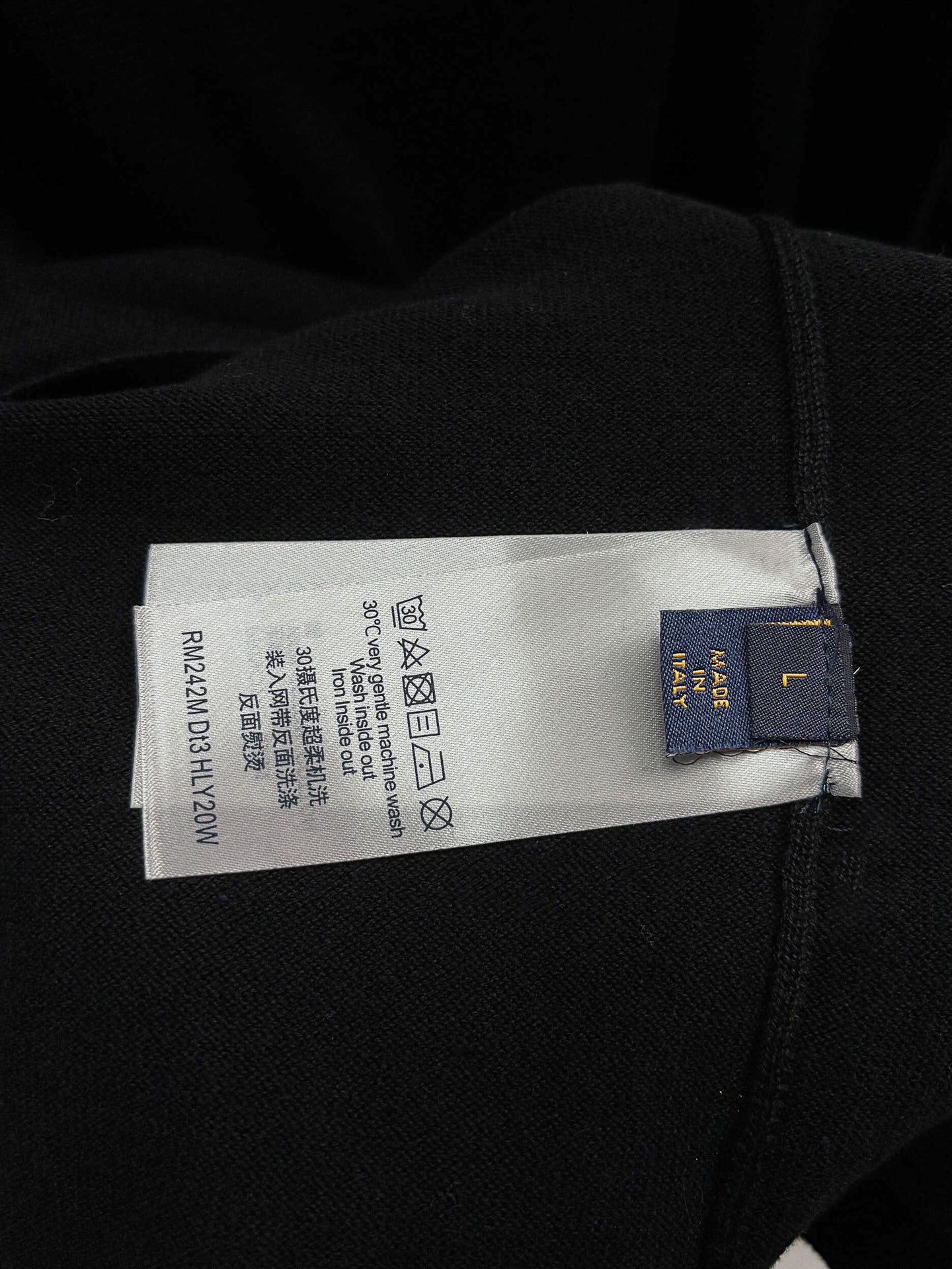 Black T-shirt care label with recycling symbols and size info