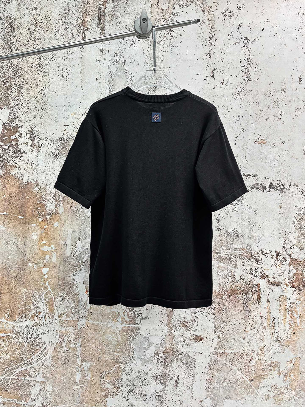 Black short-sleeve T-shirt, plain back with small logo patch near neckline