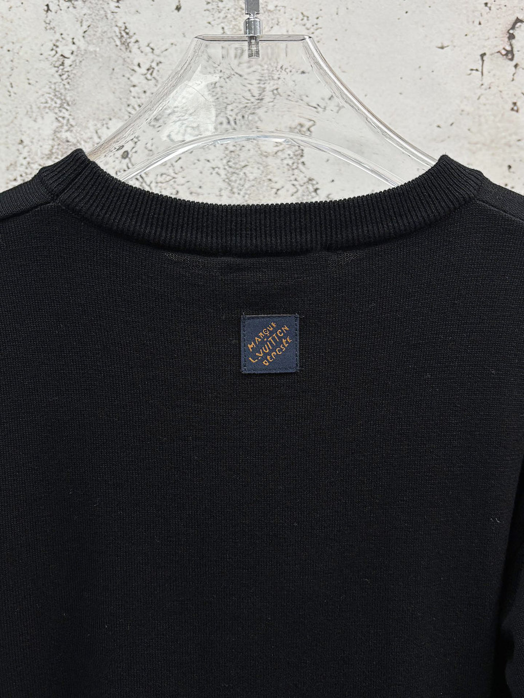 Black crew-neck T-shirt with small brand tag at back collar