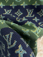 Fabric close-up of crewneck shirt with navy and green monogram knit texture