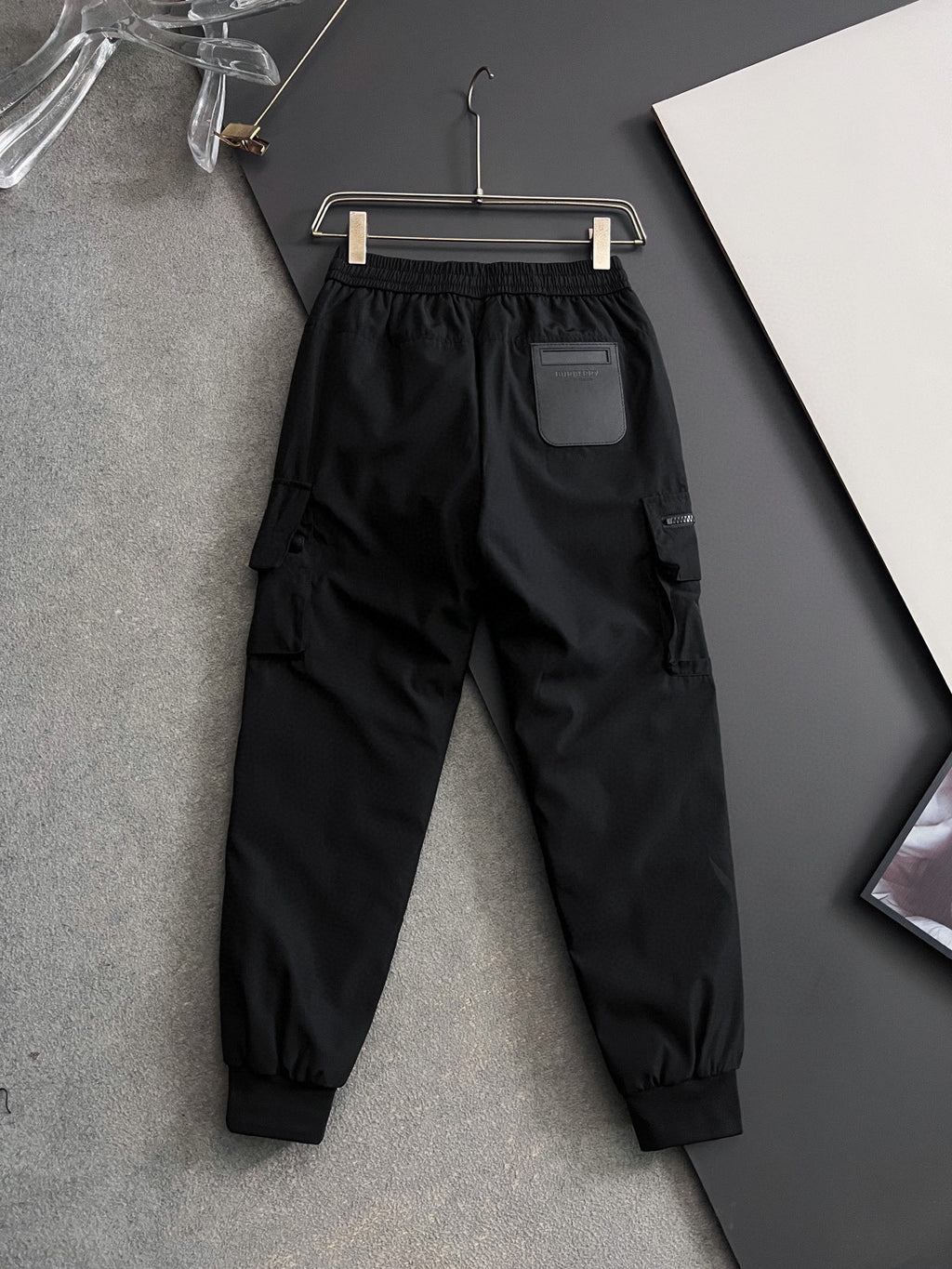 Black cargo pants with elastic waistband, drawstring, side pockets and tapered cuffs