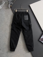 Black cargo pants with elastic waistband, drawstring, side pockets and tapered cuffs