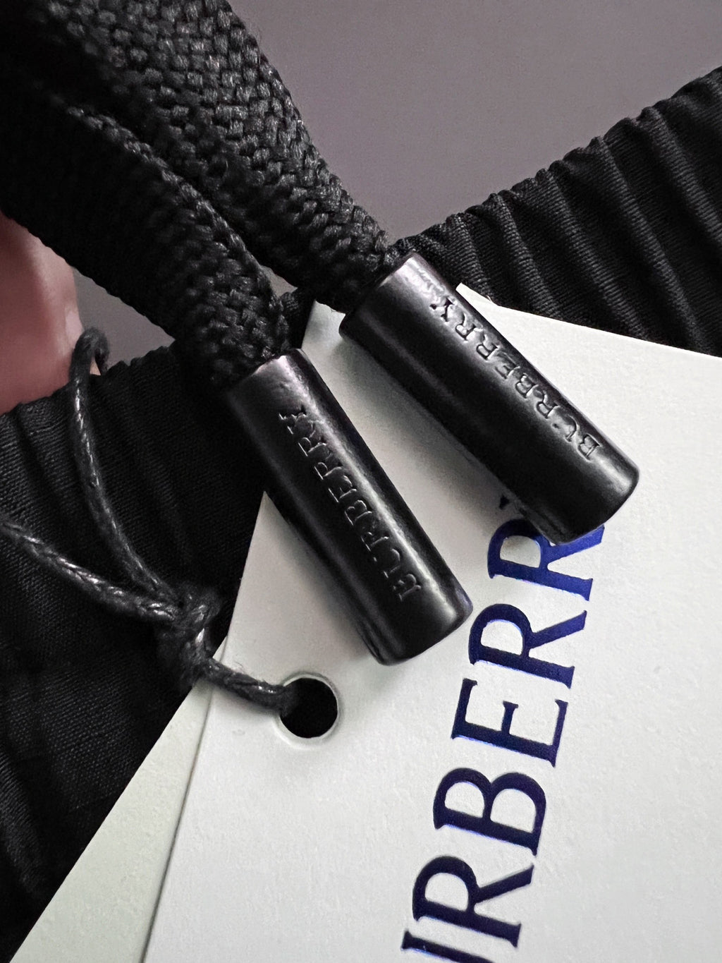 Burberry branded fabric tag with blue logo text