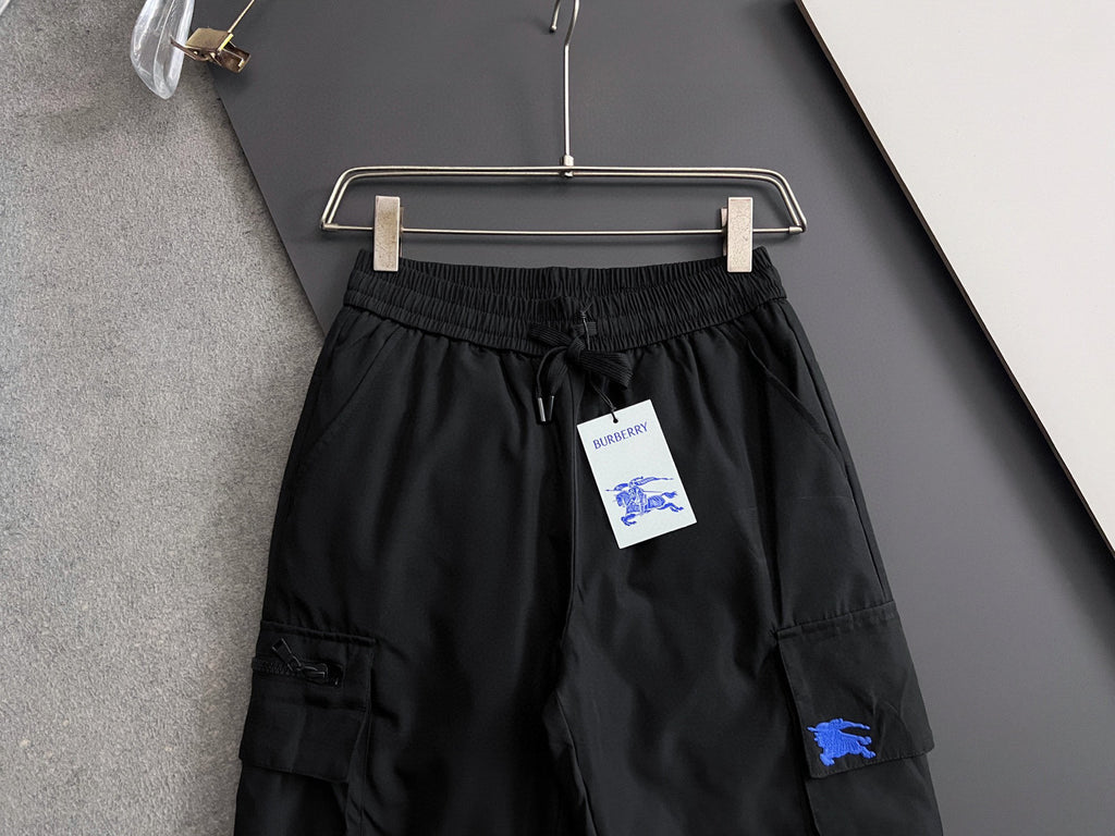 Black cargo pants on hanger, elastic waistband with drawstring and side cargo pockets