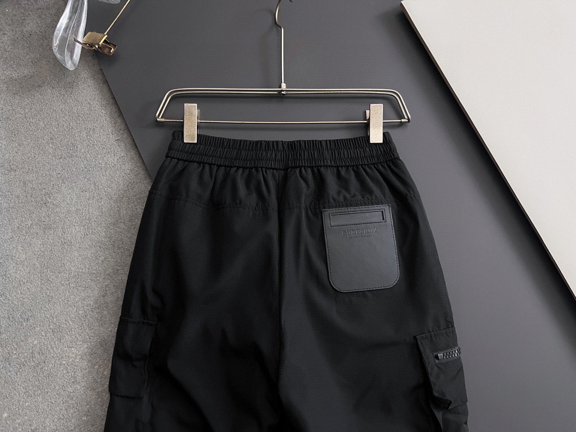 Black cargo pants with elastic waistband and drawstring, with side pocket detail