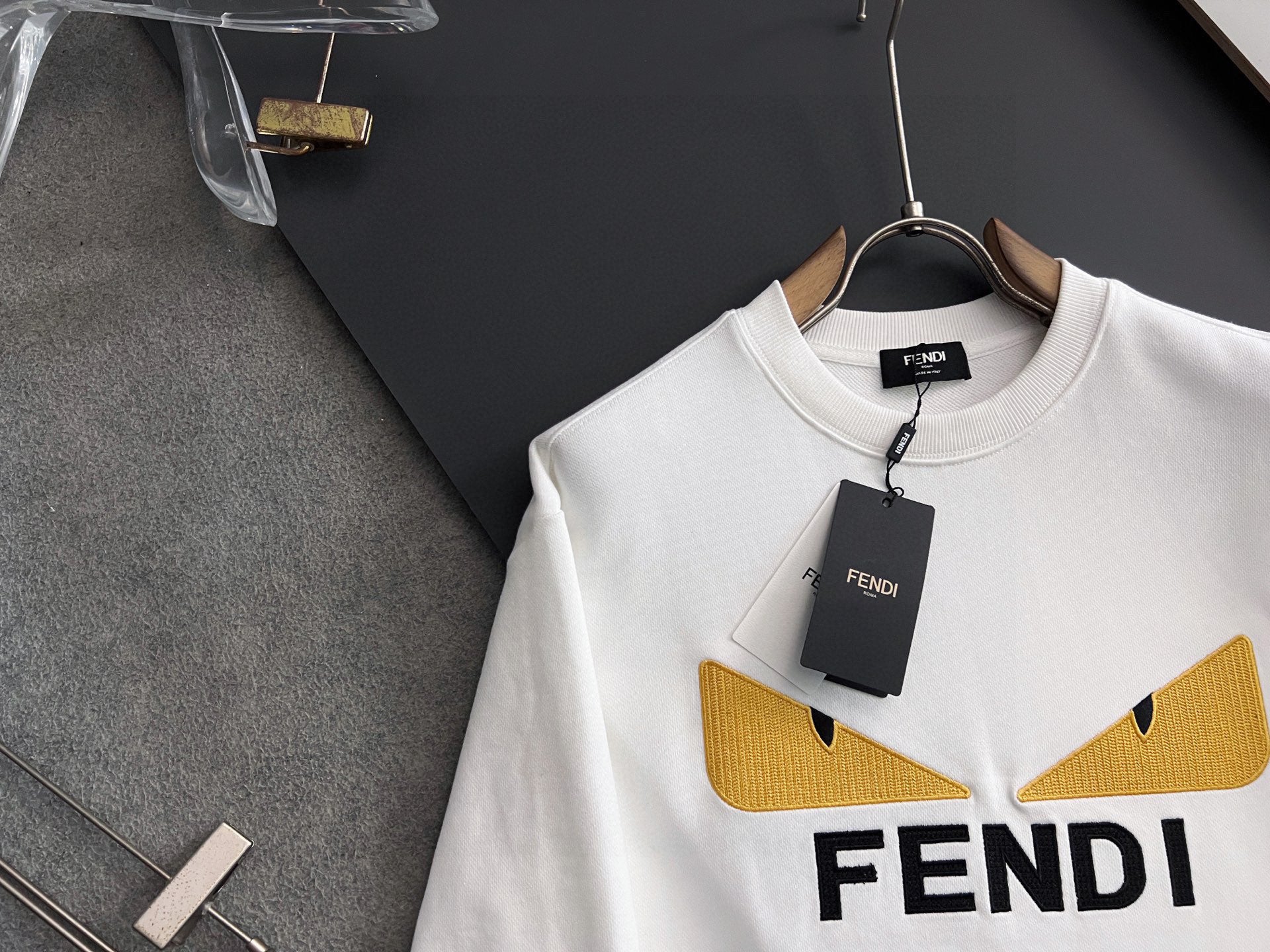 White long-sleeve sweatshirt with yellow V logo detail and FENDI lettering, hang tag