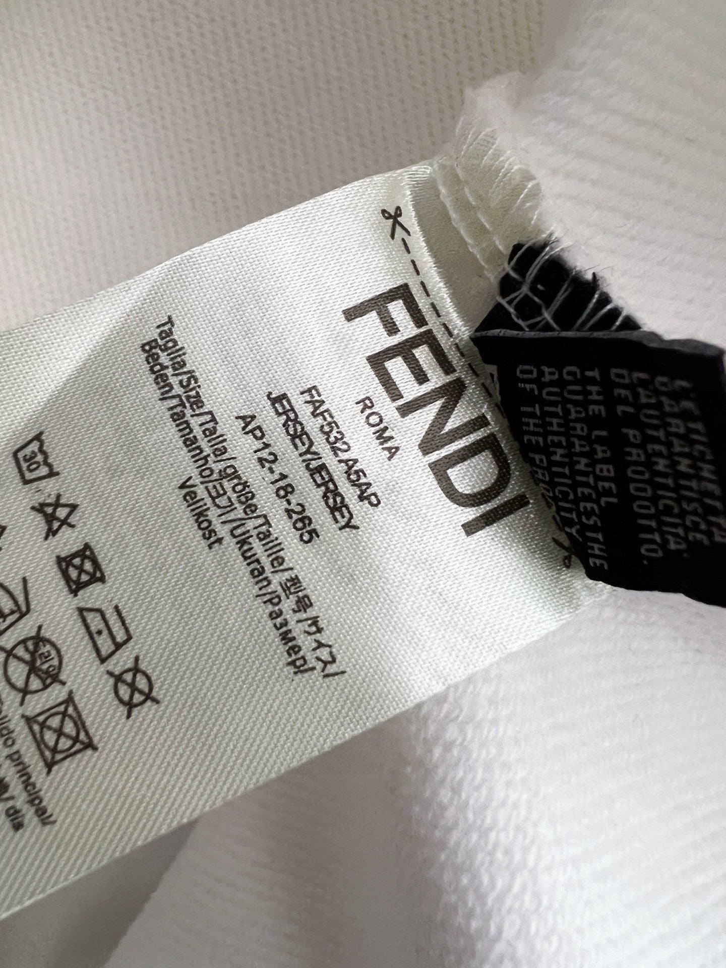 White sweatshirt fabric close-up with printed care and size label text