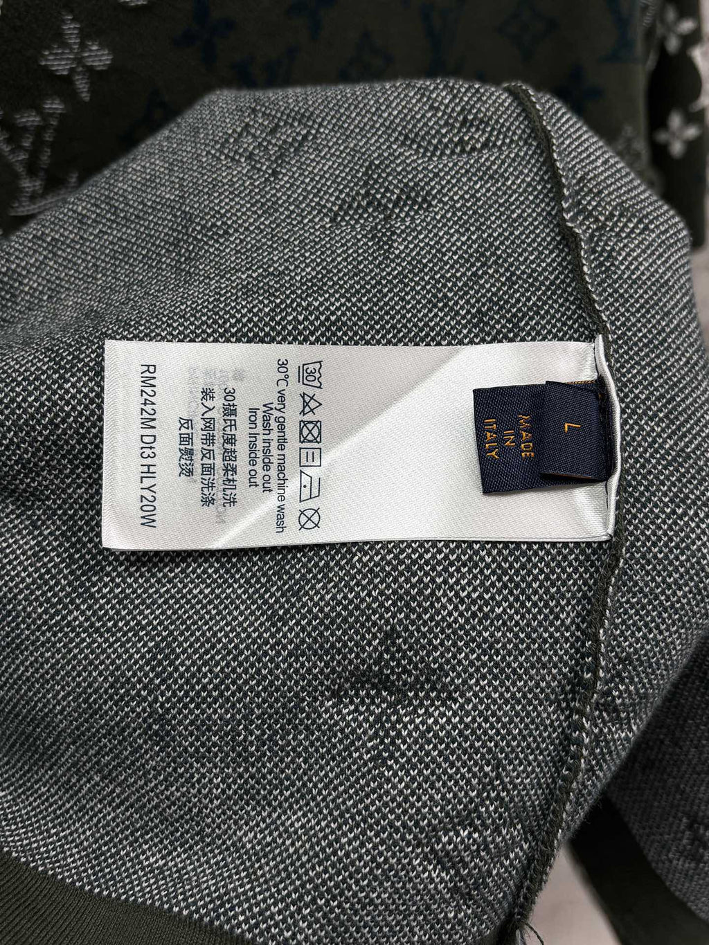 Textile care label on dark green knit T-shirt with blue-and-white logo fabric