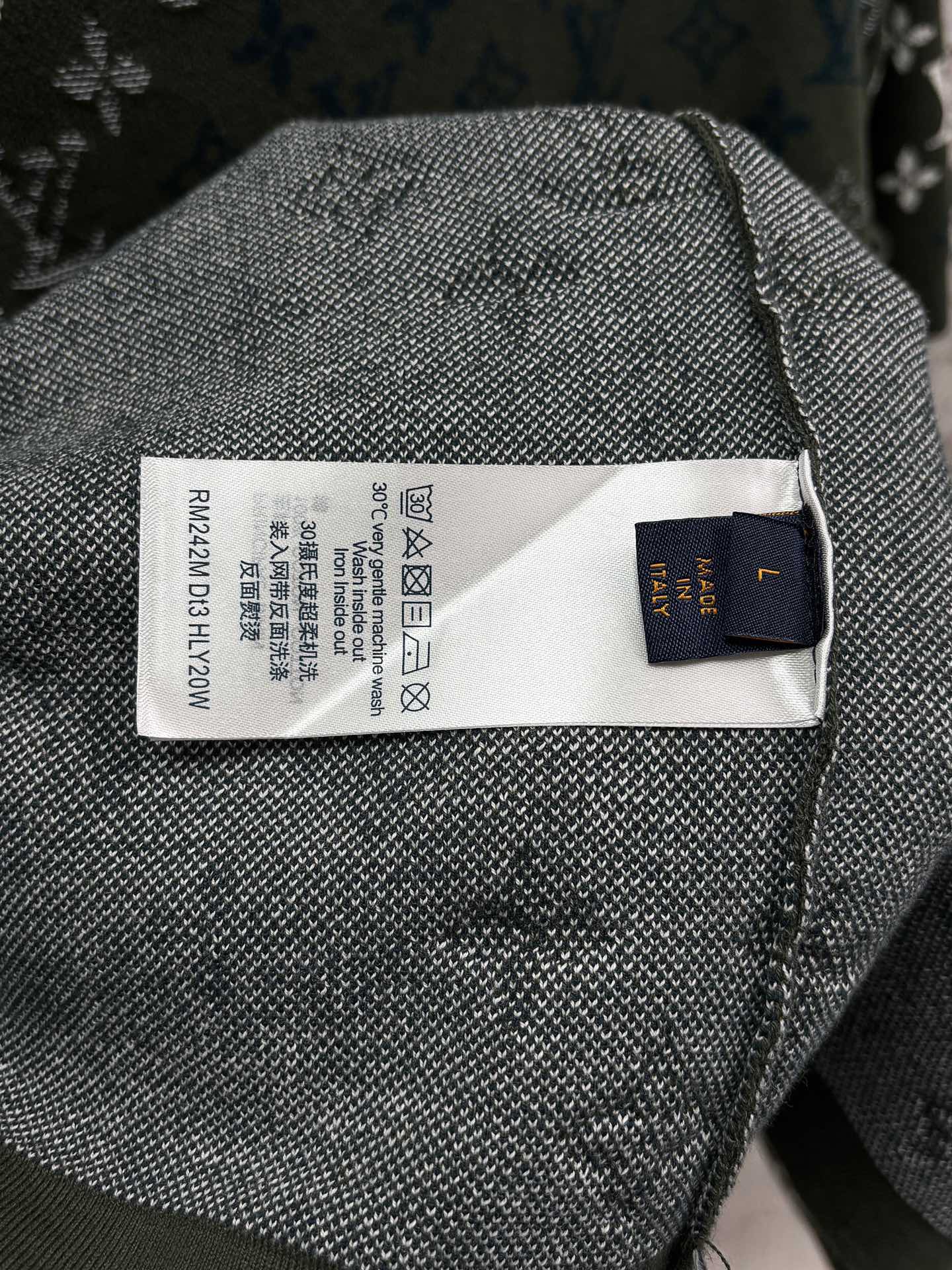 Textile care label on dark green knit T-shirt with blue-and-white logo fabric