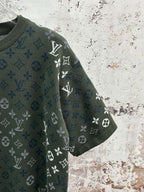 Dark green monogram T-shirt sleeve detail with blue-and-white icons and crew neck
