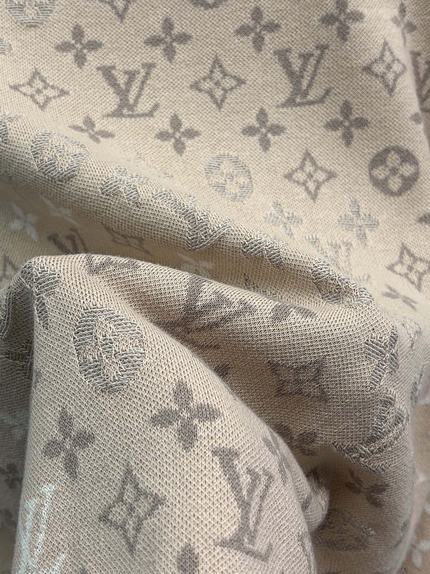 Beige monogram knit fabric with soft texture and patterned weave