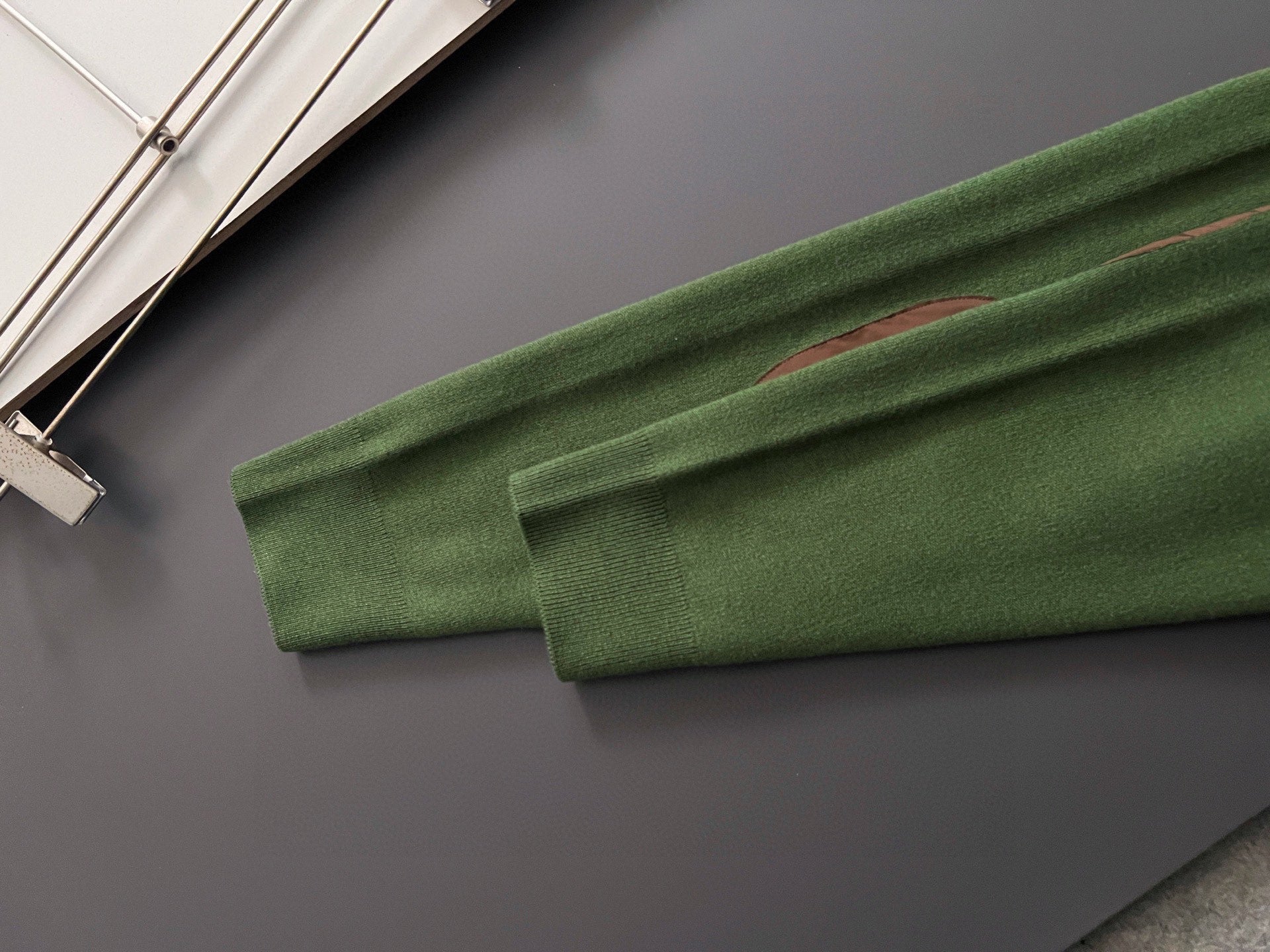 Green knit sweater sleeve cuff and hem with ribbed trim