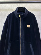 Dark navy zip-up jacket close-up with stand collar and gold-trim zipper