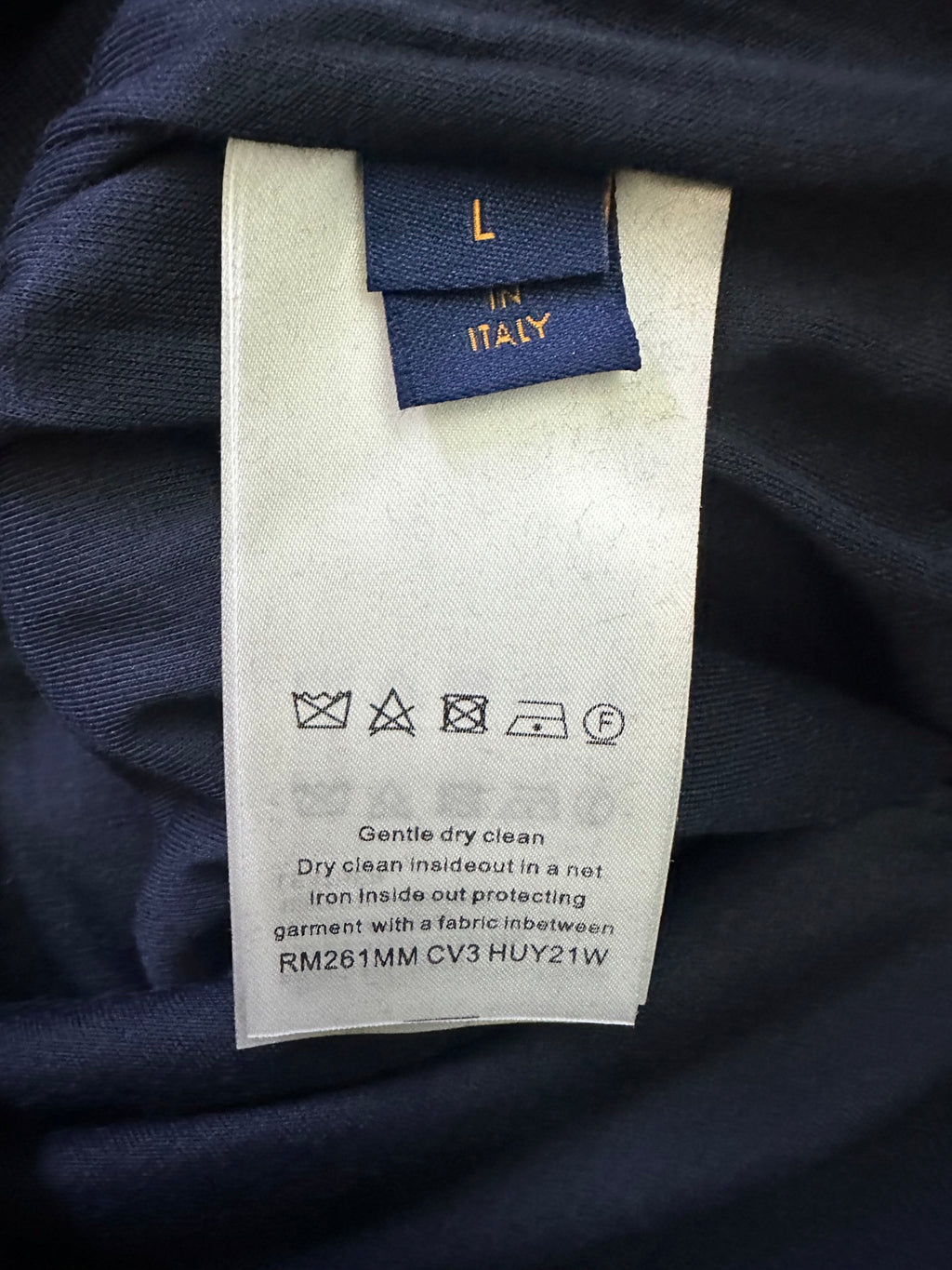 Clothing care label with "Dry clean only" and protectant symbols on fabric tag